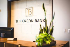 Jefferson Bank Logo with plant on the table top