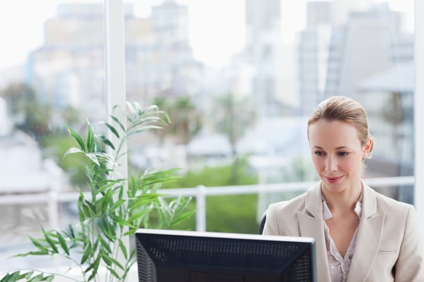 Woman working on a computer with city view in background